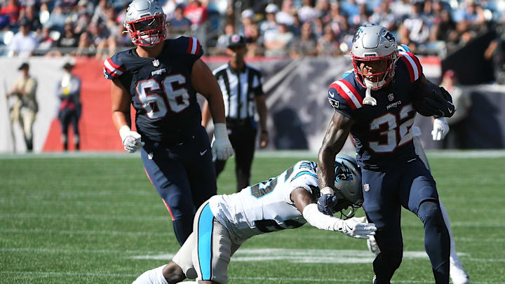 Sep 28, 2025; Foxborough, Massachusetts, USA; New England Patriots running back Treveyon Henderson (32) runs with the ball while Carolina Panthers cornerback Chau Smith-Wade (26) defends during the second half at Gillette Stadium. Mandatory Credit: Bob DeChiara-Imagn Images