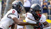 Oct 11, 2025; South Bend, Indiana, USA; NC State Wolfpack quarterback CJ Bailey (11) hands off to NC State Wolfpack running back Hollywood Smothers (3) during the first half at Notre Dame Stadium. Mandatory Credit: Michael Caterina-Imagn Images