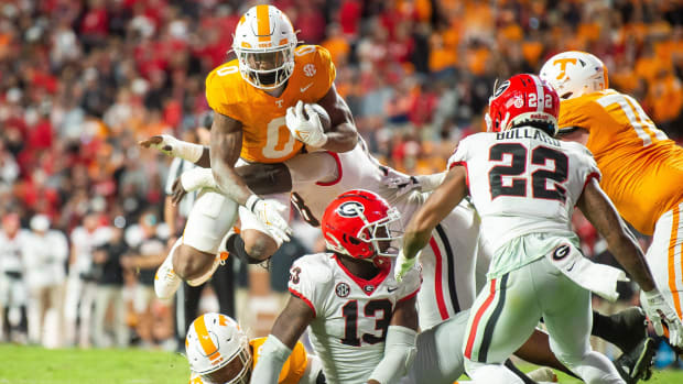 Tennessee running back Jaylen Wright (0) jumps over players as he fights for extra yards during a