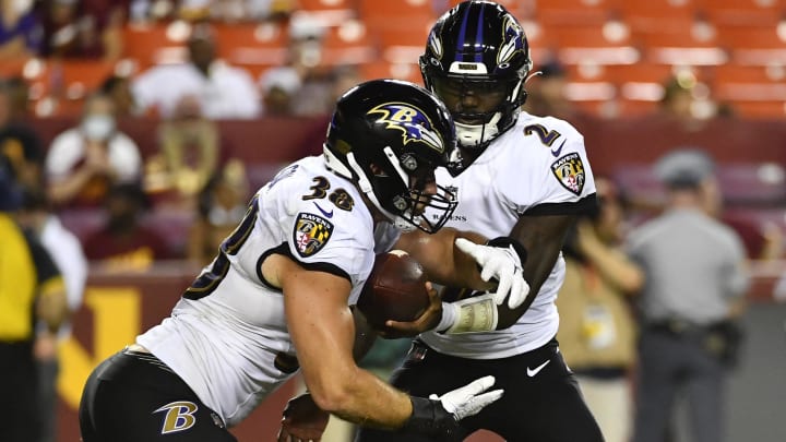 Aug 28, 2021; Landover, Maryland, USA; Baltimore Ravens quarterback Tyler Huntley (2) hands off to