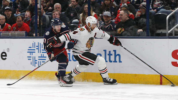 Feb 22, 2025; Columbus, Ohio, USA; Chicago Blackhawks defenseman Seth Jones (4) and Columbus Blue Jackets right wing Justin Danforth (17) go after the loose puck during the first period at Nationwide Arena. Mandatory Credit: Russell LaBounty-Imagn Images