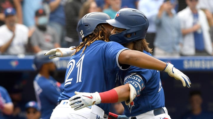 Sep 15, 2021; Toronto, Ontario, CAN;  Toronto Blue Jays shortstop Bo Bichette (11) is embraced by first baseman Vladimir Guererro Jr. (27) after hitting a three run home run against Tampa Bay Rays in the first inning at Rogers Centre. Mandatory Credit: Dan Hamilton-USA TODAY Sports