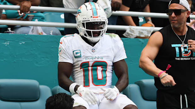 Miami Dolphins wide receiver Tyreek Hill (10) sits on the stands after running out of bounds.