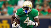 Notre Dame running back Jeremiyah Love runs the ball down the field during an NCAA college football game between Notre Dame and Louisville.