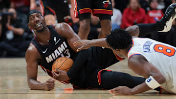 Oct 26, 2025; Miami, Florida, USA; Miami Heat center Bam Adebayo (13) recovers a loose ball against New York Knicks forward OG Anunoby (8) during the fourth quarter at Kaseya Center. Mandatory Credit: Sam Navarro-Imagn Images