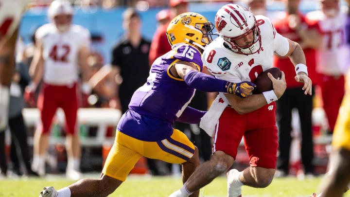 Jan 1, 2024; Tampa, FL, USA; LSU Tigers safety Sage Ryan (15) attempts to tackle Wisconsin Badgers quarterback Tanner Mordecai (8) during the first half at Raymond James Stadium. Mandatory Credit: Matt Pendleton-USA TODAY Sports