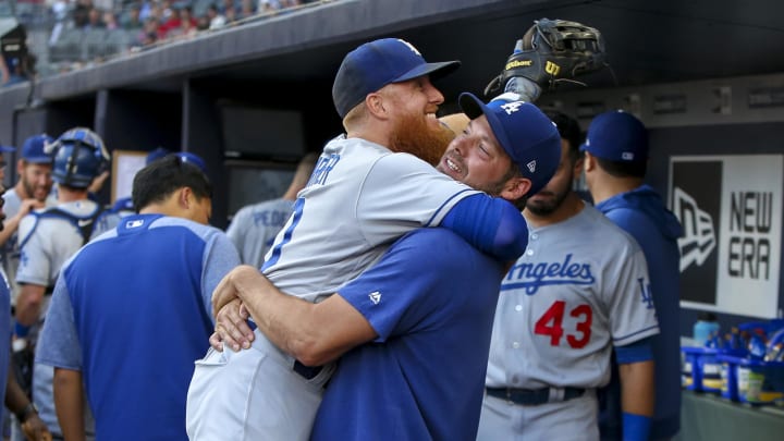 Aug 16, 2019; Atlanta, GA, USA; Los Angeles Dodgers third baseman Justin Turner (10) is held by starting pitcher Rich Hill (44) against the Atlanta Braves before a game at SunTrust Park. Mandatory Credit: Brett Davis-USA TODAY Sports