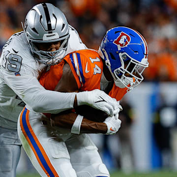 Nov 6, 2025; Denver, Colorado, USA; Denver Broncos wide receiver Courtland Sutton (14) is tackled by Las Vegas Raiders defensive end Charles Snowden (49) in the fourth quarter at Empower Field at Mile High. Mandatory Credit: Isaiah J. Downing-Imagn Images