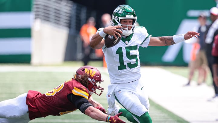 Aug 10, 2024; East Rutherford, New Jersey, USA; New York Jets quarterback Adrian Martinez (15) scrambles for a first down as Washington Commanders safety Ben Nikkel (48) pursues during the second half at MetLife Stadium.