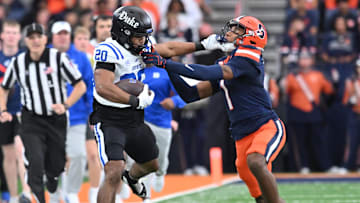 Sep 27, 2025; Syracuse, New York, USA; Duke Blue Devils running back Nate Sheppard (20) tries to hold off a tackle by Syracuse Orange defensive back Demetres Samuel Jr. (1) in the second quarter at the JMA Wireless Dome. Mandatory Credit: Mark Konezny-Imagn Images