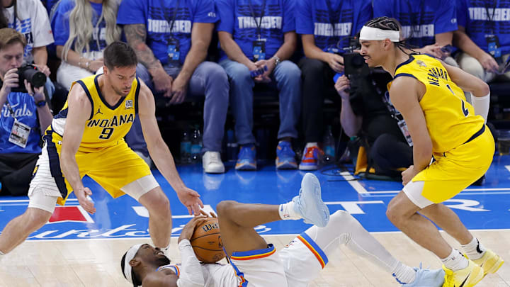 Jun 16, 2025; Oklahoma City, Oklahoma, USA; Oklahoma City Thunder guard Shai Gilgeous-Alexander (2) grabs a loose ball as Indiana Pacers guard T.J. McConnell (9) and guard Andrew Nembhard (2) look on during the third quarter in game five of the 2025 NBA Finals at Paycom Center. Mandatory Credit: Alonzo Adams-Imagn Images Jun 16, 2025; Oklahoma City, Oklahoma, USA; Oklahoma City Thunder guard Shai Gilgeous-Alexander (2) grabs a loose ball as Indiana Pacers guard T.J. McConnell (9) and guard Andrew Nembhard (2) look on during the third quarter in game five of the 2025 NBA Finals at Paycom Center. Mandatory Credit: Alonzo Adams-Imagn Images