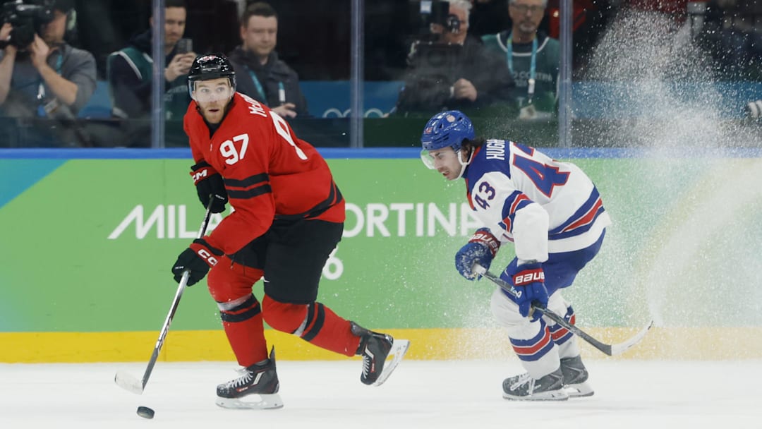 Feb 22, 2026; Milan, Italy; Connor McDavid (97) of Canada in action against Quinn Hughes (43) of the United States in the men's ice hockey gold medal game during the Milano Cortina 2026 Olympic Winter Games at Milano Santagiulia Ice Hockey Arena. Mandatory Credit: Geoff Burke-Imagn Images