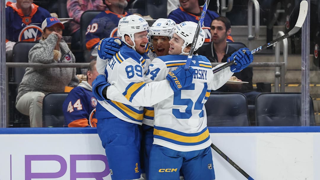 Nov 22, 2025; Elmont, New York, USA;  St. Louis Blues center Brayden Schenn (10) celebrates with left wing Pavel Buchnevich (89) and right wing Dalibor Dvorsky (54) after scoring a goal in the first period against the New York Islanders at UBS Arena. Mandatory Credit: Wendell Cruz-Imagn Images