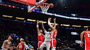 Apr 4, 2025; Inglewood, California, USA; Dallas Mavericks forward Naji Marshall (13) plays for the rebound against Los Angeles Clippers guard Trentyn Flowers (9) and forward Patrick Baldwin Jr. (23) during the second half at Intuit Dome. Mandatory Credit: Gary A. Vasquez-Imagn Images