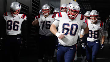 Dec 7, 2023; Pittsburgh, Pennsylvania, USA;  New England Patriots center David Andrews (60) leads the Patriots onto the field against the Pittsburgh Steelers at Acrisure Stadium. Mandatory Credit: Charles LeClaire-Imagn Images