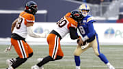 Nov 13, 2022; Winnigeg, Manitoba, CAN; BC Lions defensive lineman Mathieu Betts (90) tackles Winnipeg Blue Bombers quarterback Zach Collaros (8) in the first half at Investors Group Field. Mandatory Credit: James Carey Lauder-Imagn Images