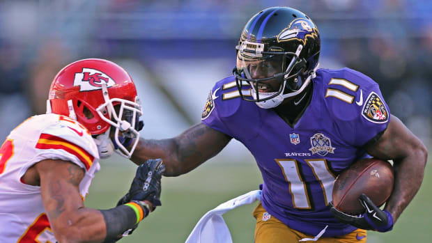 Baltimore Ravens receiver Kamar Aiken fends off a Kansas City Chiefs defender