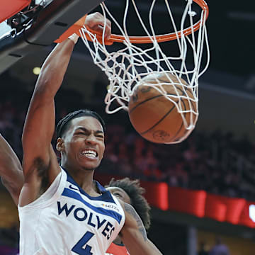 Feb 21, 2025; Houston, Texas, USA; Minnesota Timberwolves guard Rob Dillingham (4) dunks the ball as Houston Rockets forward Jae'Sean Tate (8) defends during the third quarter at Toyota Center. Mandatory Credit: Troy Taormina-Imagn Images
