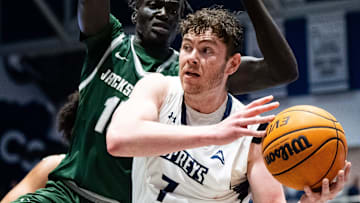 Jacksonville Dolphins forward Tito Deng (15) pressures North Florida Ospreys forward Liam Murphy (7)