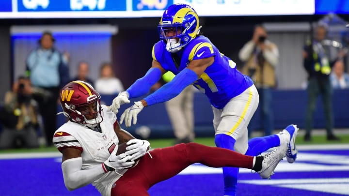 Dec 17, 2023; Inglewood, California, USA; Washington Commanders wide receiver Curtis Samuel (4) scores a touchdown ahead of Los Angeles Rams safety Quentin Lake (37) during the second half at SoFi Stadium. 