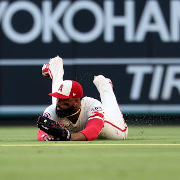 Jul 29, 2025; Anaheim, California, USA;  Los Angeles Angels center fielder Jo Adell (7) is unable to handle a ball hit for a single by Texas Rangers left fielder Sam Haggerty (0, not pictured) during the first inning at Angel Stadium. Mandatory Credit: Kiyoshi Mio-Imagn Images