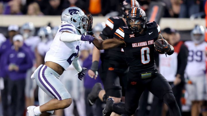 Oklahoma State's Ollie Gordon II (0) tries to get by Kansas State's Kobe Savage (2) in the first half of the college football game between the Oklahoma State University Cowboys and the Kansas State Wildcats at Boone Pickens Stadium in Stillwater. Okla., Friday, Oct. 6, 2023. OSU won 29-21.