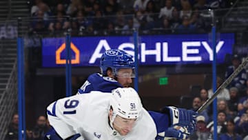 Apr 9, 2025; Tampa, Florida, USA; Tampa Bay Lightning defenseman Nick Perbix (48) and Toronto Maple Leafs center John Tavares (91) fight to control the puck during the second period at Amalie Arena. Mandatory Credit: Kim Klement Neitzel-Imagn Images
