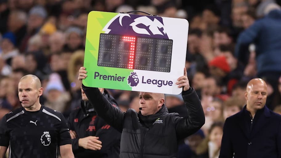 Fourth official holding up a board.