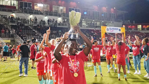 Kansas City Current forward Temwa Chawinga carries the '24 Summer Cup trophy.