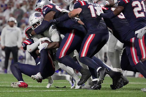 Buffalo Bills running back James Cook is brought down by a host of Patriot players during first half action at Highmark Stadi