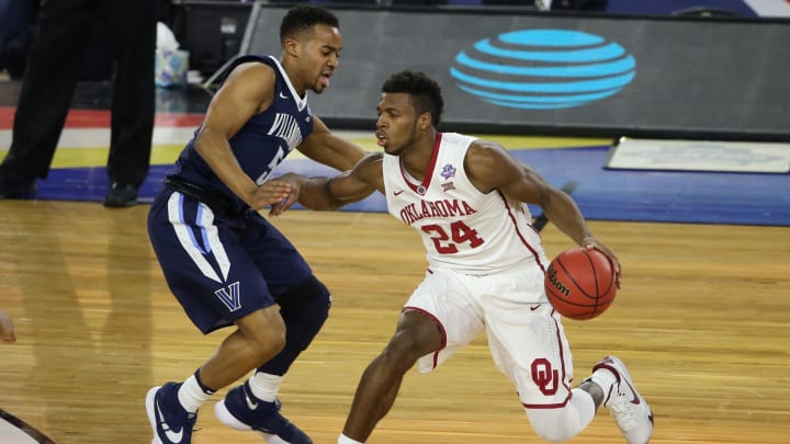 Buddy Hield of the Oklahoma Sooners drives around Villanova guard Phil Booth in an NCAA Championship semifinal game in 2016.
