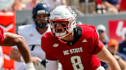 Sep 6, 2025; Raleigh, North Carolina, USA; North Carolina State Wolfpack offensive lineman Rico Jackson (64) celebrates a tackle against Virginia Cavaliers running back J'Mari Taylor (3) during the first half of the game at Carter-Finley Stadium. Mandatory Credit: Jaylynn Nash-Imagn Images