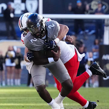 Nov 11, 2023; Boulder, Colorado, USA; Arizona Wildcats linebacker Dominic Lolesio (42) tackles Colorado Buffaloes quarterback Shedeur Sanders (2) in the second half at Folsom Field. Mandatory Credit: Ron Chenoy-Imagn Images