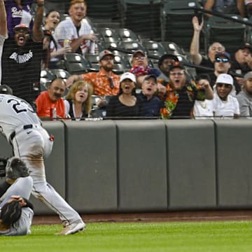 Sep 3, 2024; Baltimore, Maryland, USA;  Chicago White Sox third baseman Miguel Vargas (20) and outfielder Andrew Benintendi (23) react after colliding on Baltimore Orioles designated hitter Eloy Jiménez (not pictured) second inning fly ball  at Oriole Park at Camden Yards.