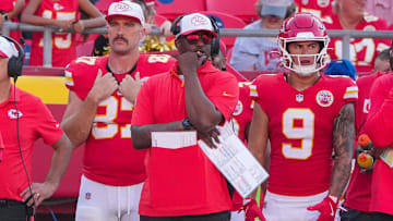 Kansas City Chiefs tight end Travis Kelce (87) and former running back Louis Rees-Zammit (9) watch play on the sidelines against the Detroit Lions during the game at GEHA Field at Arrowhead Stadium.