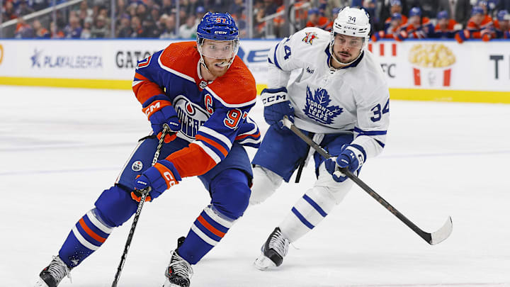 Edmonton Oilers forward Connor McDavid carries the puck around Toronto Maple Leafs forward Auston Matthews.