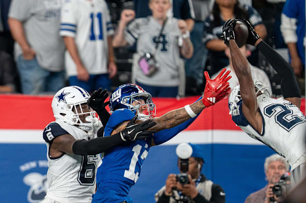 Dallas Cowboys cornerback Amani Oruwariye intercepts a pass intended for New York Giants wide receiver Wan'Dale Robinson.