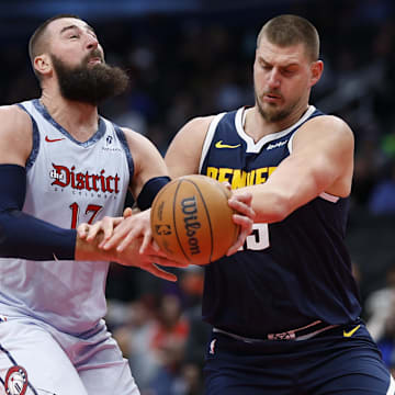 Dec 7, 2024; Washington, District of Columbia, USA; Washington Wizards center Jonas Valanciunas (17) is fouled while driving to the basket by Denver Nuggets center Nikola Jokic (15) in the third quarter at Capital One Arena. Mandatory Credit: Geoff Burke-Imagn Images
