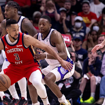 Apr 19, 2024; New Orleans, Louisiana, USA;  New Orleans Pelicans guard CJ McCollum (3) dribbles against Sacramento Kings guard De'Aaron Fox (5) in the second half during a play-in game of the 2024 NBA playoffs at Smoothie King Center.