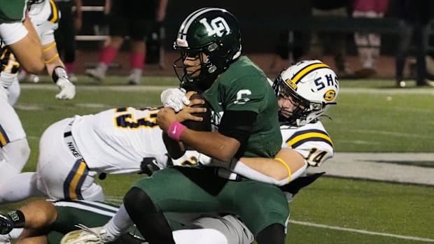 Lake Orion quarterback Tristan Hill protects the ball against Salinas on Friday, Oct. 25, 2024.