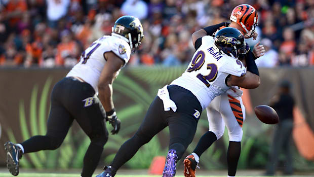 Oct 26, 2014; Cincinnati, OH, USA; Baltimore Ravens defensive end Haloti Ngata (92) knocks the ball away from Cincinnati Bengals quarterback Andy Dalton (14) during the fourth quarter at Paul Brown Stadium.