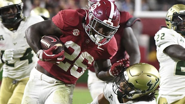 Alabama running back Jam Miller stiff arms South Florida defensive lineman Jah-Marien Latham.