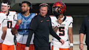 Oct 26, 2024; Berkeley, California, USA; Oregon State Beavers head coach Trent Bray (center) walks on the sideline in front of quarterbacks Dom Montiel (center left) and Gabarri Johnson (5) during the fourth quarter against the California Golden Bears at California Memorial Stadium. Mandatory Credit: Darren Yamashita-Imagn Images