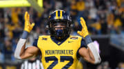 Dec 27, 2023; Charlotte, NC, USA; West Virginia Mountaineers running back Jahiem White (22) reacts after scoring a touchdown in the fourth quarter at Bank of America Stadium. Mandatory Credit: Bob Donnan-USA TODAY Sports