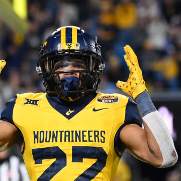 Dec 27, 2023; Charlotte, NC, USA; West Virginia Mountaineers running back Jahiem White (22) reacts after scoring a touchdown in the fourth quarter at Bank of America Stadium. Mandatory Credit: Bob Donnan-USA TODAY Sports