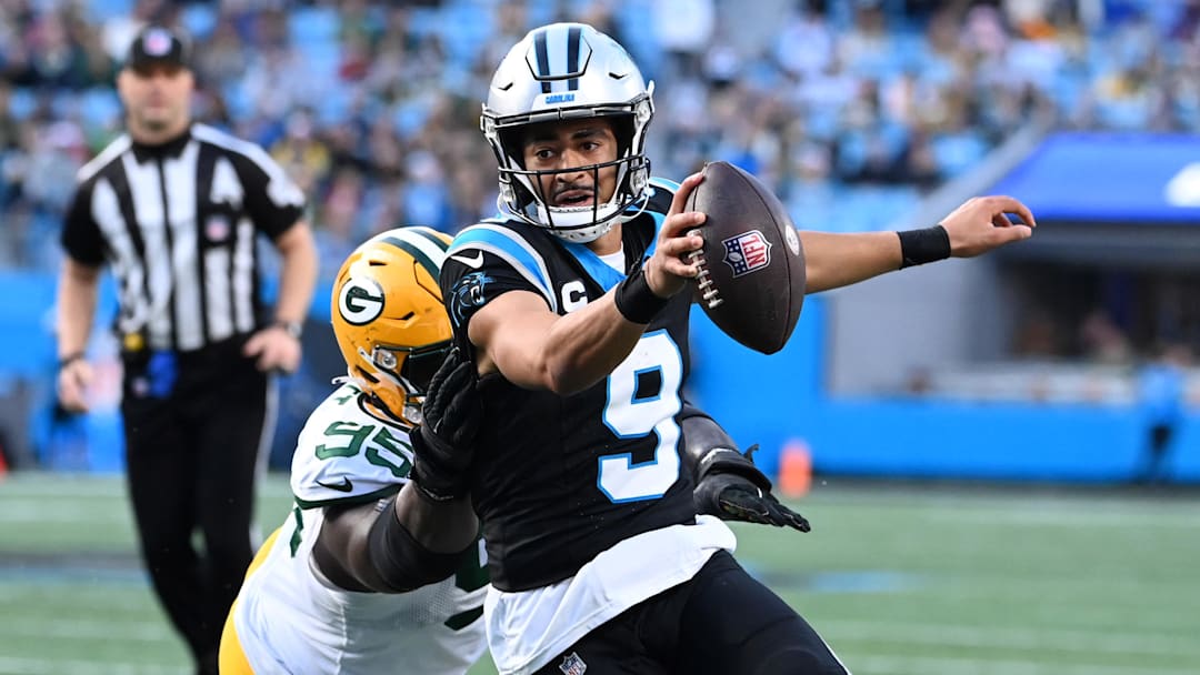 Dec 24, 2023; Charlotte, North Carolina, USA; Carolina Panthers quarterback Bryce Young (9) scrambles as Green Bay Packers defensive tackle Devonte Wyatt (95) defends in the fourth quarter at Bank of America Stadium. Mandatory Credit: Bob Donnan-Imagn Images