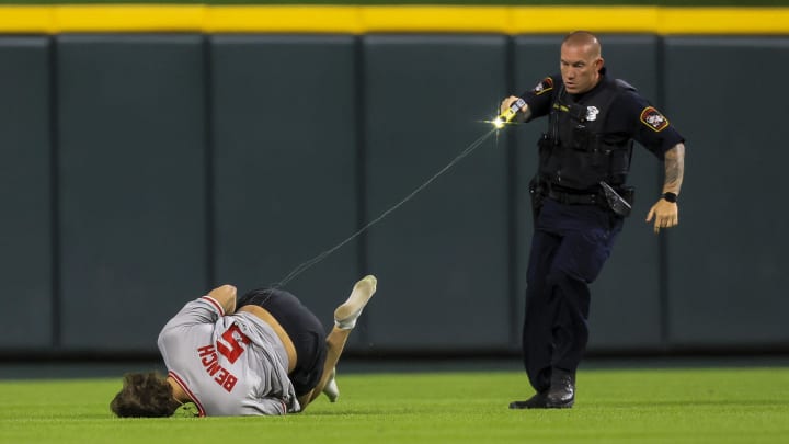 A police officer tases a Cincinnati Reds fan that ran onto the field in the ninth inning of the game against the Cleveland Guardians at Great American Ball Park.