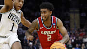 Mar 23, 2025; Cleveland, OH, USA; New Mexico Lobos guard Donovan Dent (2) dribbles the ball defended by Michigan State Spartans guard Jeremy Fears Jr. (1) in the second half during the NCAA Tournament Second Round at Rocket Arena. Mandatory Credit: Rick Osentoski-Imagn Images