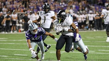 Sep 23, 2023; Manhattan, Kansas, USA; UCF Knights running back RJ Harvey (7) is stopped just short of the goal line by Kansas State Wildcats cornerback Will Lee III (8) and cornerback Jacob Parrish (10) during the fourth quarter at Bill Snyder Family Football Stadium. Mandatory Credit: Scott Sewell-Imagn Images