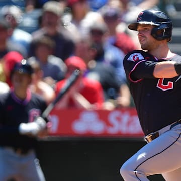 Apr 6, 2025; Anaheim, California, USA; Cleveland Guardians center fielder Lane Thomas (8) hits a sacrifice RBI against the Los Angeles Angels during the first inning at Angel Stadium. Mandatory Credit: Gary A. Vasquez-Imagn Images